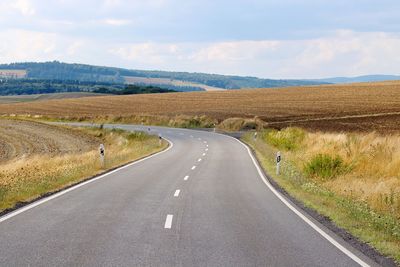 Road passing through landscape against sky