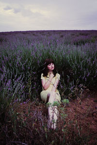 Woman standing on field with purple flowers