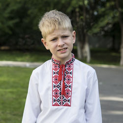 Portrait of boy wearing traditional clothing against trees