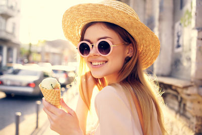 Portrait of young woman wearing sunglasses hat