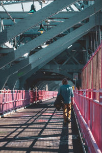 Rear view of woman walking on bridge