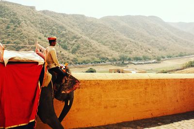 Rear view of man on desert against sky