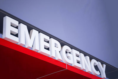 Low angle view of information sign against clear blue sky