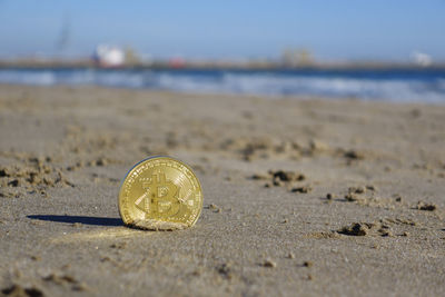 Close-up of coin on beach