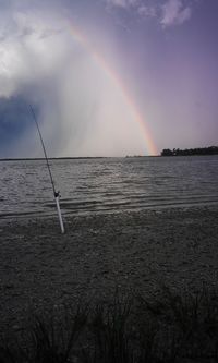 Scenic view of rainbow over sea against sky