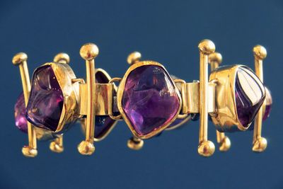 Close-up of gold jewelry over colored background