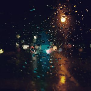 Wet city street seen through glass window