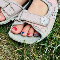 Low section of woman wearing shoes on field