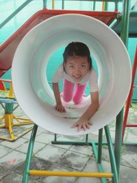 Portrait of smiling girl sitting on chair at playground