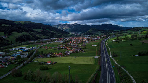 High angle view of field by buildings against sky