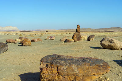 Scenic view of rocks on land against clear blue sky