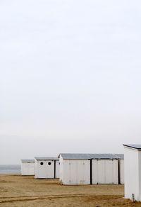 Cropped built structures on landscape against clear sky