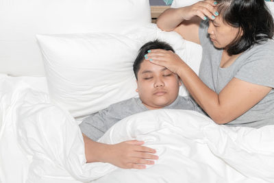 Midsection of woman lying on bed