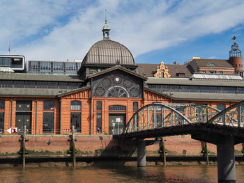 Arch bridge over river against buildings in city