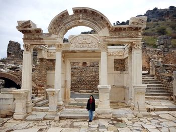 Woman standing against old ruins