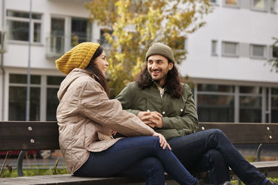 Man and woman talking on bench