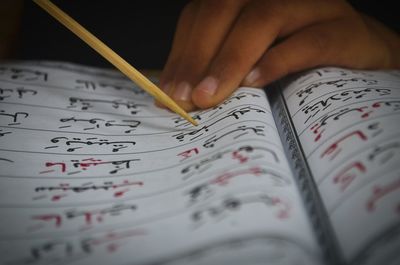 Cropped hand of student reading book