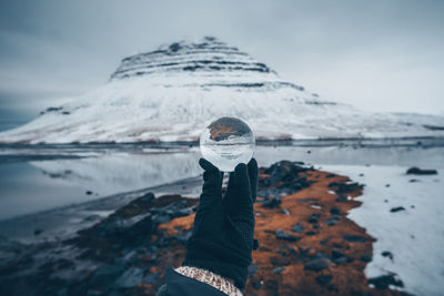 Man standing on snowcapped mountain against sky