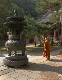 Rear view of woman walking against building