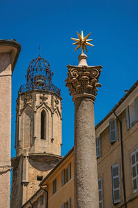 Column with golden star on top and bell tower at aix-en-provence, in the french provence.