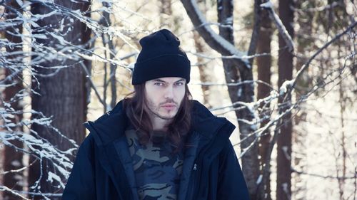 Portrait of young woman in forest during winter