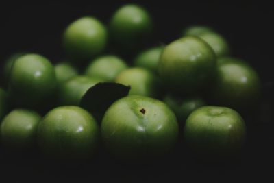 Close-up of green plums in dark