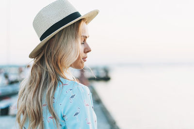 Portrait of woman standing at beach against sky