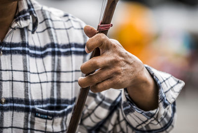 Cropped image of man holding string instrument