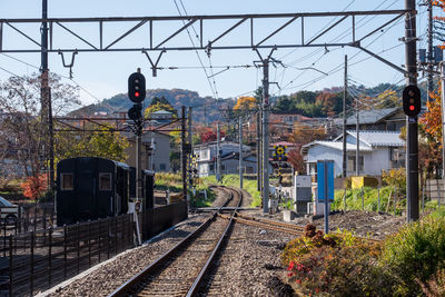 Railroad tracks by trees against sky