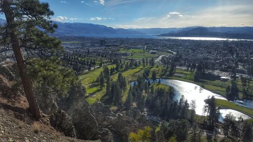 Scenic view of river by mountains against sky