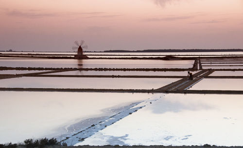 Scenic view of frozen lake against sky during sunset