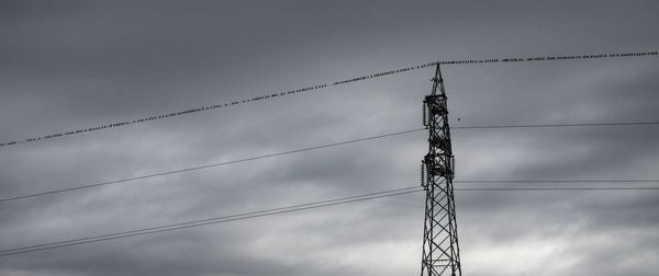 Low angle view of electricity pylon against sky