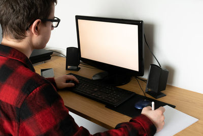 Midsection of man using laptop on table