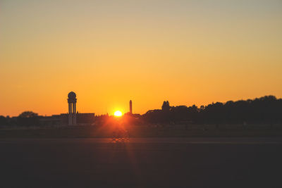 Silhouette landscape against clear sky during sunset