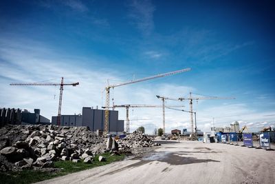 Cranes at construction site against sky