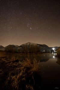 Scenic view of lake against sky at night