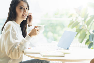 Young woman using laptop on table