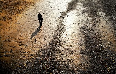 High angle view of silhouette man standing on road