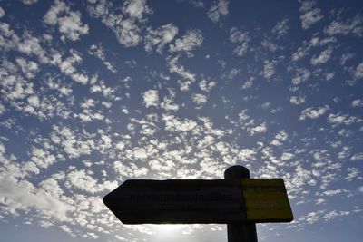Low angle view of road sign against sky