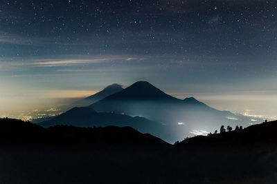 Scenic view of silhouette mountains against sky at night