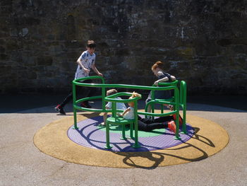 Rear view of two people sitting on floor