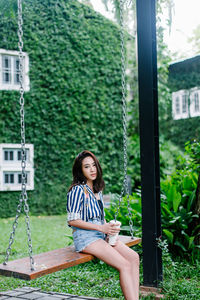 Portrait of woman sitting on swing