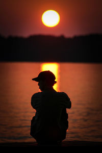 Silhouette man against sea during sunset