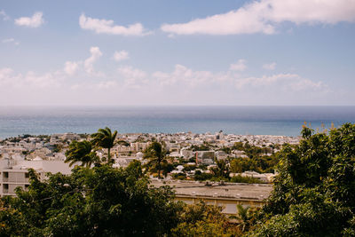 High angle view of buildings and sea against sky