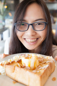 Close-up of young woman holding dessert in plate