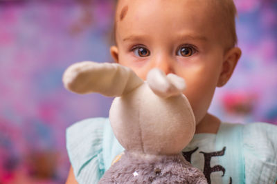 Close-up of cute baby girl kissing rabbit