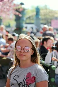 Portrait of smiling woman with sunglasses against blurred background