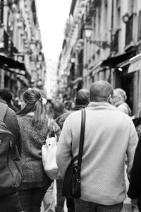 Rear view of people walking on city street