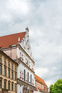 Low angle view of buildings against cloudy sky