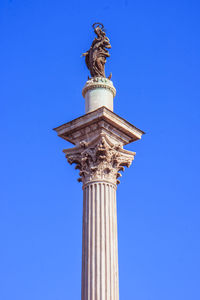 Low angle view of statue against blue sky